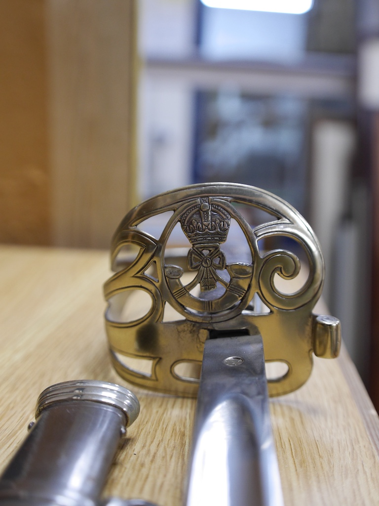 An officer's sword and WWII helmet. Condition - fair